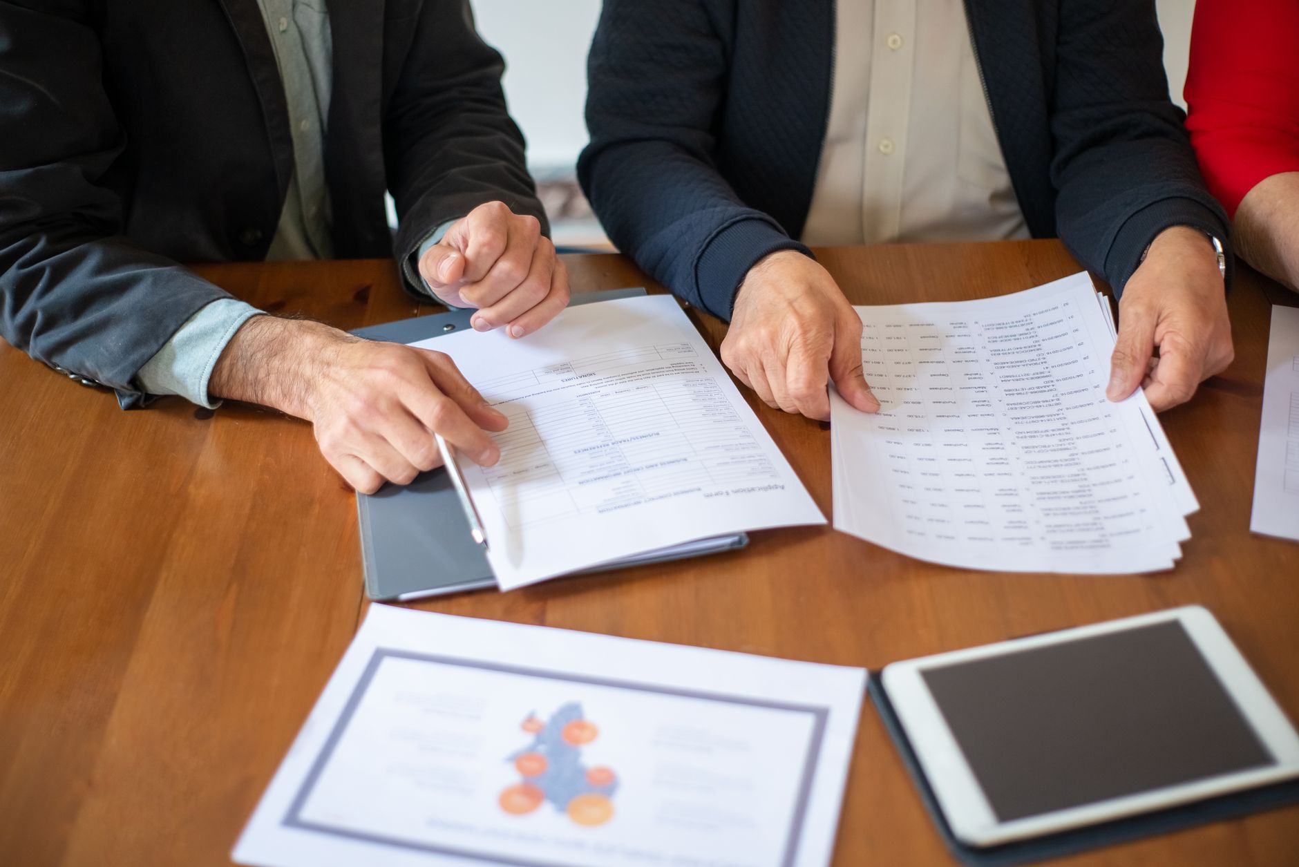 Two business professionals discussing and reviewing documents during a meeting.
